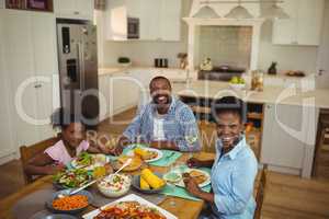 Portrait of family having meal on dinning table at home