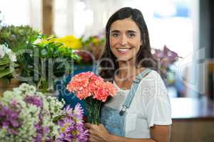 Smiling woman selecting flowers at florist shop