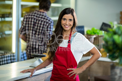 Smiling woman vendor standing at the counter in grocery store