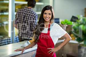 Smiling woman vendor standing at the counter in grocery store