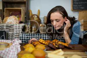 Woman smelling bread at bakery counter