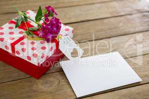Gift box with happy mothers day tag and pink flowers