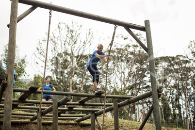 Fit woman holding the rope during obstacle course