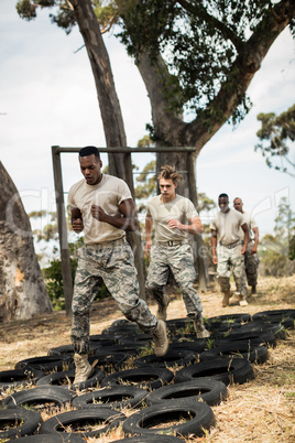 Young military soldiers practicing tyre obstacle course