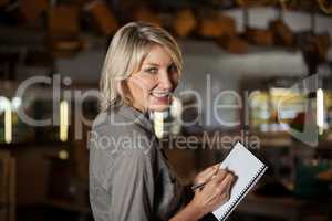 Portrait of female costumer maintain record in notepad
