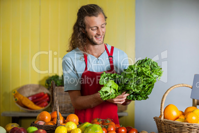 Smiling staff looking at leafy vegetables at counter