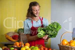 Smiling staff looking at leafy vegetables at counter