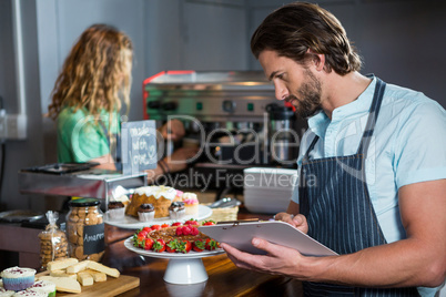 Male staff maintaining a record on clipboard at counter