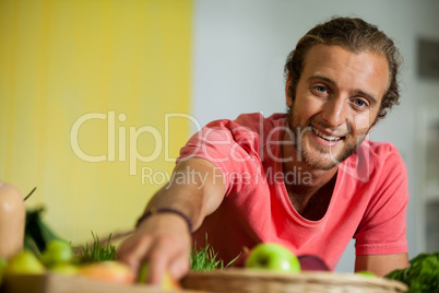 Portrait of male staff arranging fruit in organic section