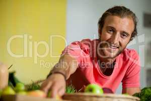 Portrait of male staff arranging fruit in organic section