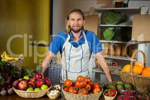 Male staff standing near vegetable counter at organic section in market