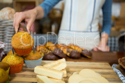 Mid-section of staff working at bakery counter