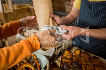 Customer paying bill by cash at bread counter