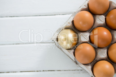 Golden Easter egg with brown eggs in tray