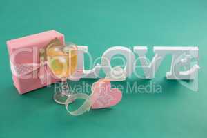Gift box and alphabet love on green background