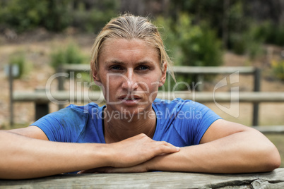 Woman leaning on a hurdle during obstacle course