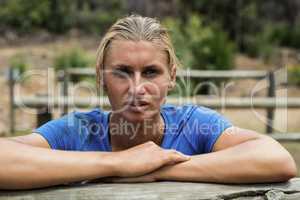 Woman leaning on a hurdle during obstacle course