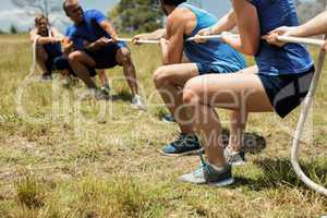 People playing tug of war during obstacle training course