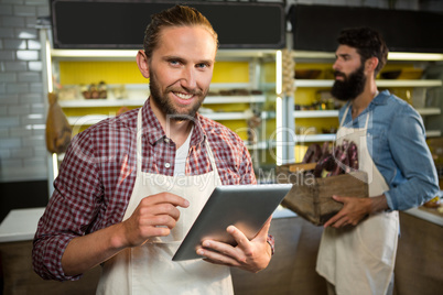 Portrait of smiling staff using digital tablet