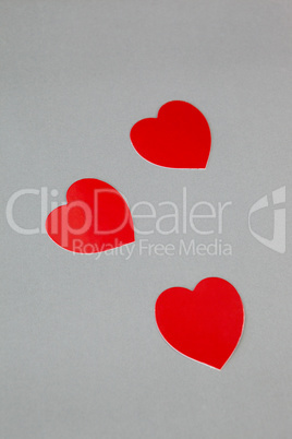 Three red hearts on grey background