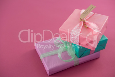 Gift boxes with happy mother day tag against pink background