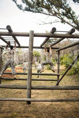 Soldiers climbing monkey bars