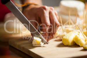 Staff cutting cheese at counter in market