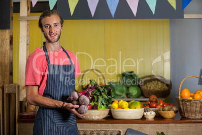 Portrait of male staff holding turnip in organic section
