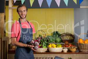 Portrait of male staff holding turnip in organic section