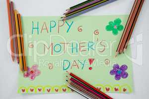 Color pencil arranged around mothers day greetings card