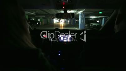 Girl driving car in covered parking garage