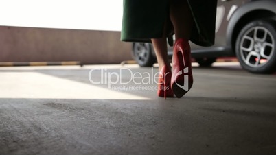 Elegant female legs walking to parked car