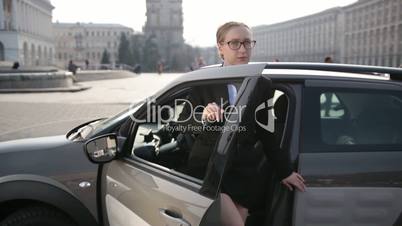 Determined business lady stepping out of car