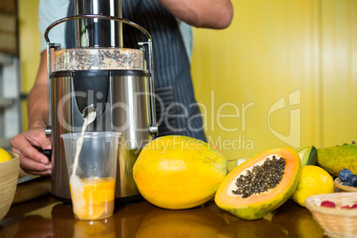 Shop assistant preparing papaya juice