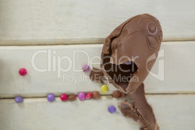 Broken chocolate Easter egg on wooden plank