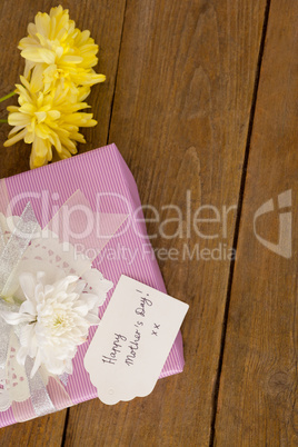 Happy mothers day card on gift box with flowers