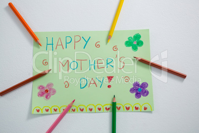 Color pencil arranged around mothers day greetings card