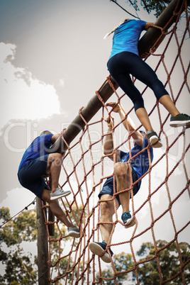 People climbing a net during obstacle course