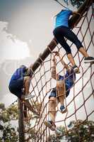 People climbing a net during obstacle course