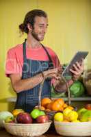 Smiling male staff using digital tablet in organic section