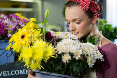 Female florist smelling a bunch of flower