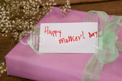 Happy mothers day card on gift box with flowers