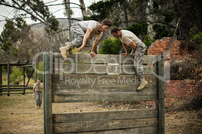 Soldiers climbing wooden wall