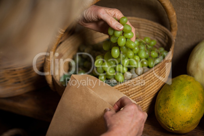 Staff packing grapes in paper bag