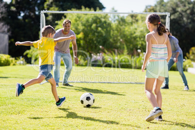 Family playing football together at the park