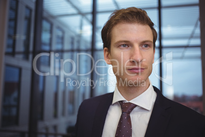 Thoughtful businessman standing in corridor