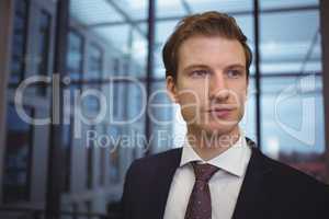 Thoughtful businessman standing in corridor