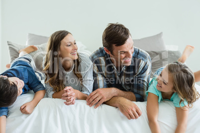 Family playing on bed in bedroom at home