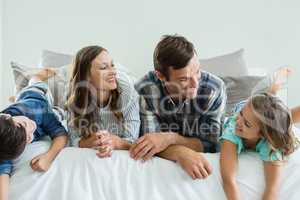 Family playing on bed in bedroom at home