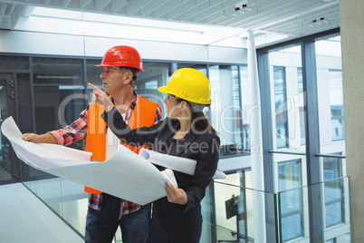 Businesswoman discussing over blueprint with an architect